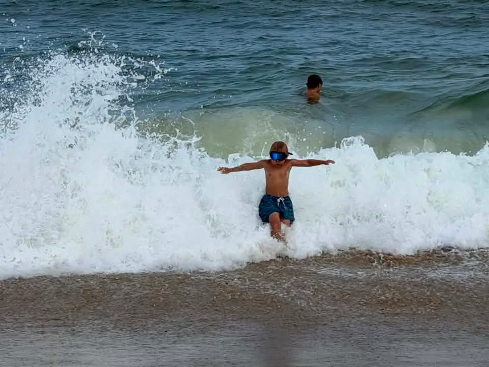 boy playing in the waves in ocean city md