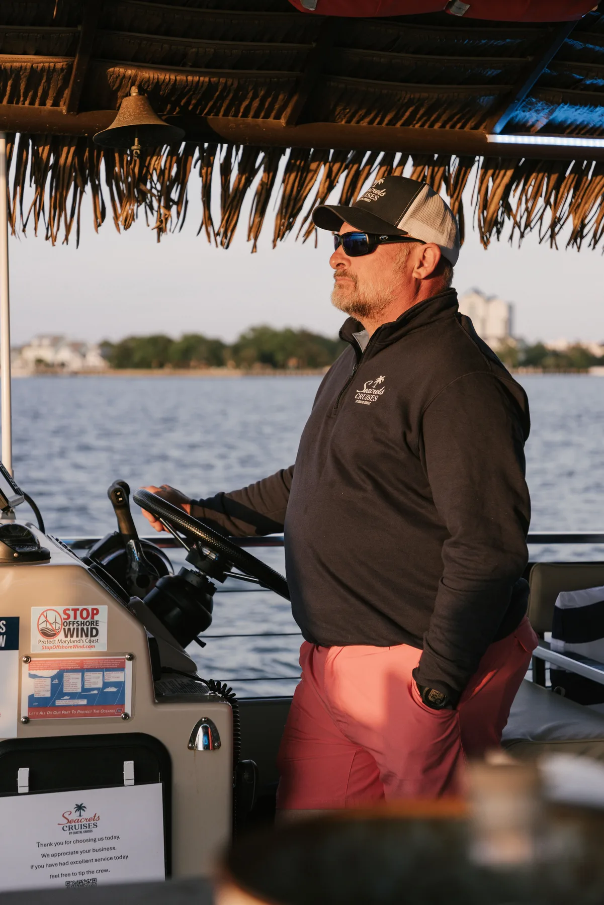 Captain Mike steering a Seacrets Cruises boat on the back bays of Ocean City, Maryland.