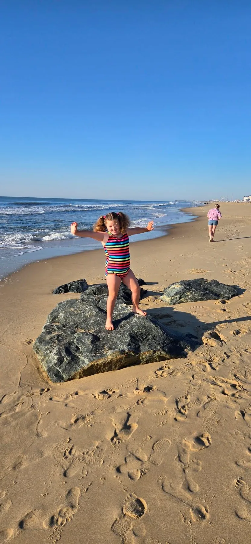 girl jumping over a rock in ocean city md